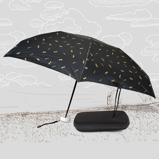 A black DrizzlePro umbrella with small gold musical note patterns is open next to its black zippered case on a sketched