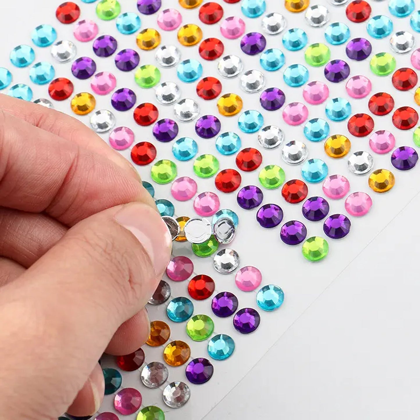 Shining stone stickers being applied to a mobile phone and other craft items.