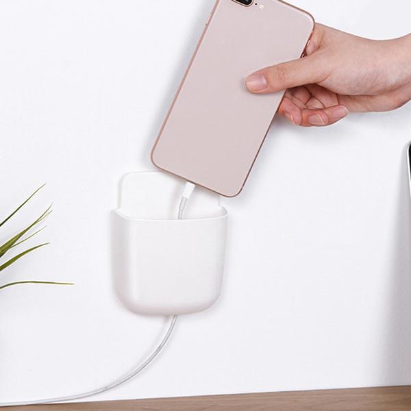 Side view of a mobile phone charging in the wall mounted stand, highlighting the bottom charging port.